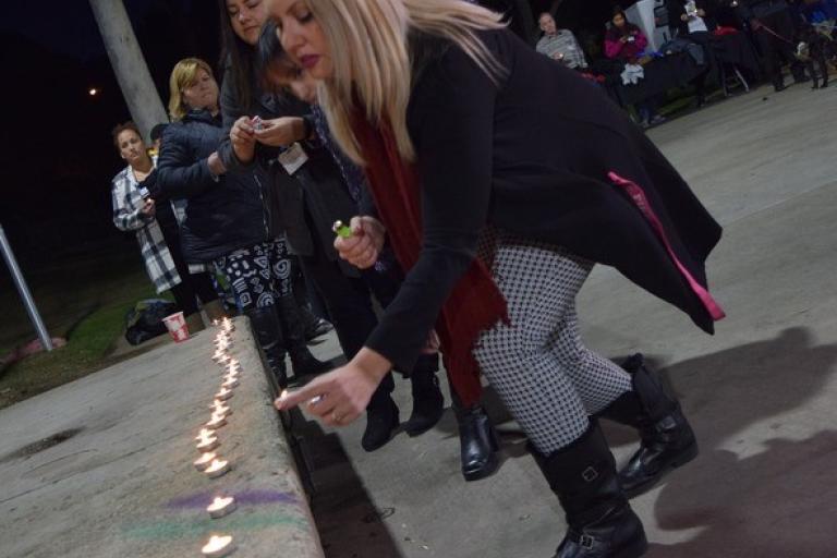 People gather to light candles in remembrance of unhoused residents lost and to bring awareness to homeless services. 